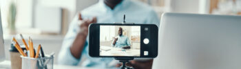 young businessman in shirt telling something and smiling while making social media video
