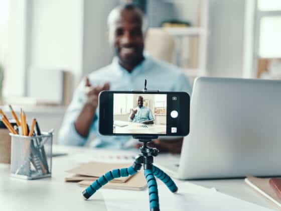 young businessman in shirt telling something and smiling while making social media video