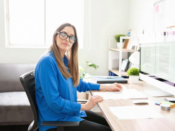 Content writer working in home office wearing a blue shirt and glasses.